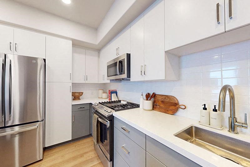a kitchen with stainless steel appliances and white cabinets at The Villas at Anacapa Canyon, California