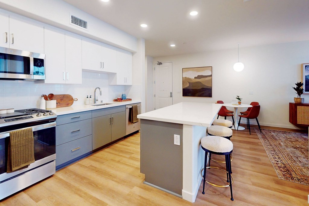 A kitchen with a white island and stools at The Villas at Anacapa Canyon, Camarillo, 93012