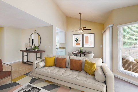 A living room with a white couch and a rug on the floor.