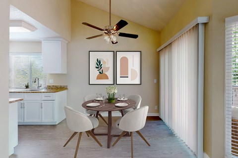 A dining room with a table set for two and a ceiling fan.