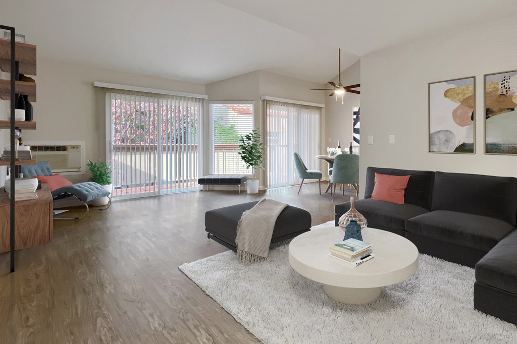 A living room with a black couch, a white coffee table, and a ceiling fan at Valley Plaza Villages, California, 94566