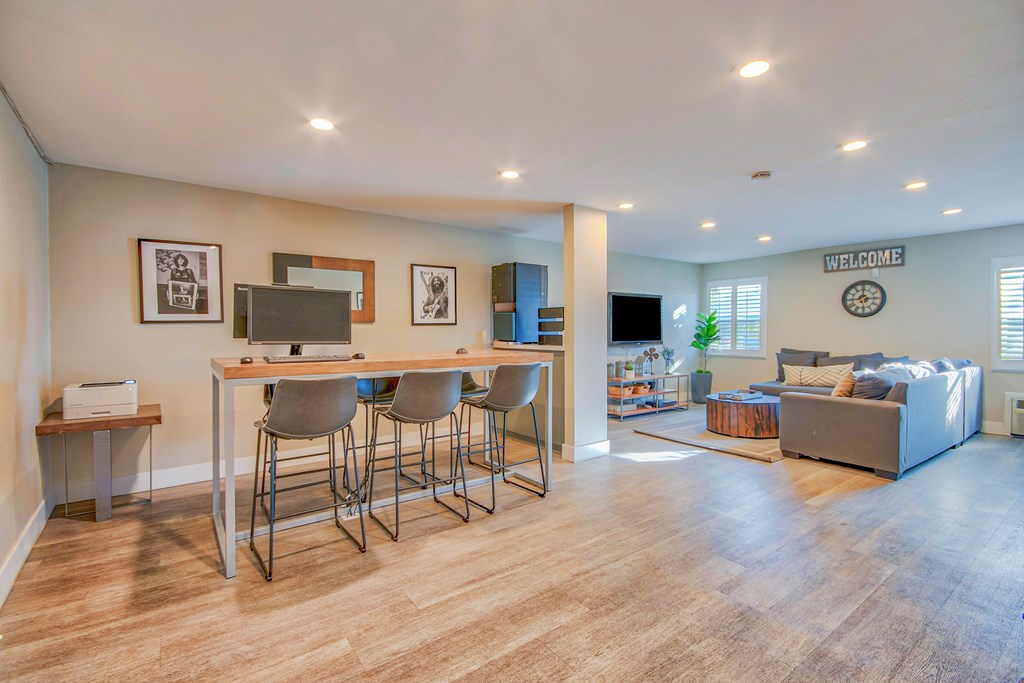 A living room with a couch, a table, and a television at Villa Vicente, Los Angeles, CA