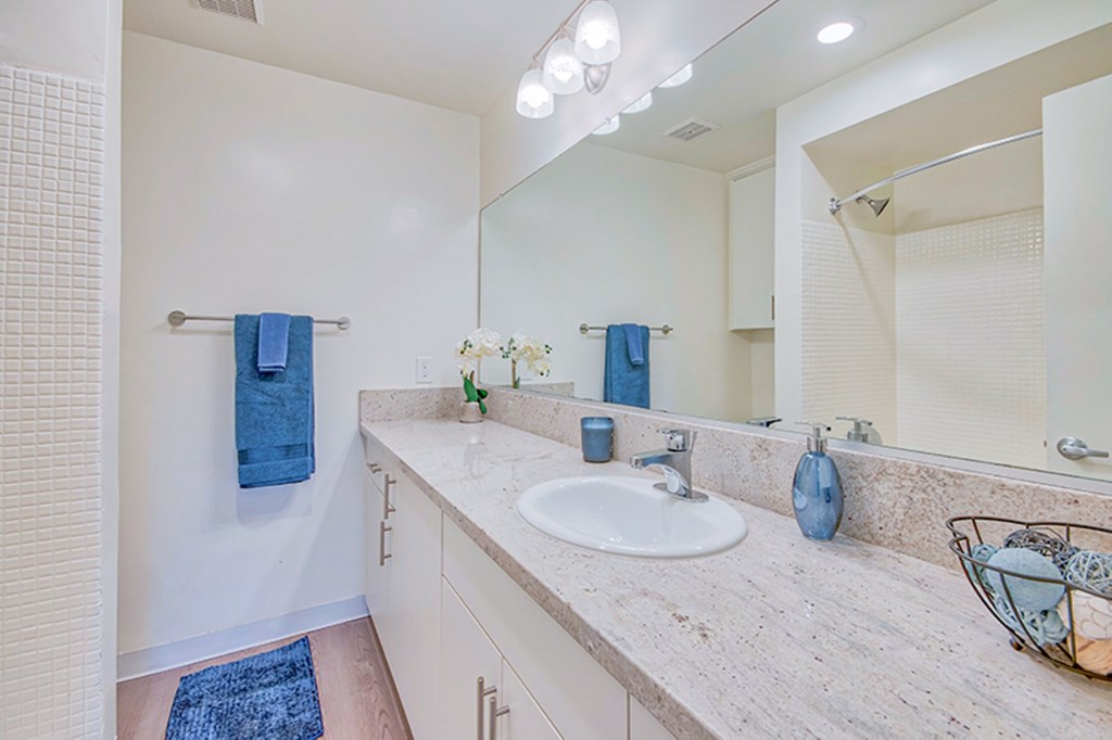 A bathroom with a sink, mirror, and towel rack at Villa Vicente, Los Angeles, CA