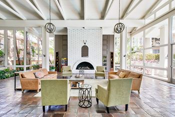 A living room with a fireplace and a white brick wall at Mediterranean Village Costa Mesa, Costa Mesa, CA