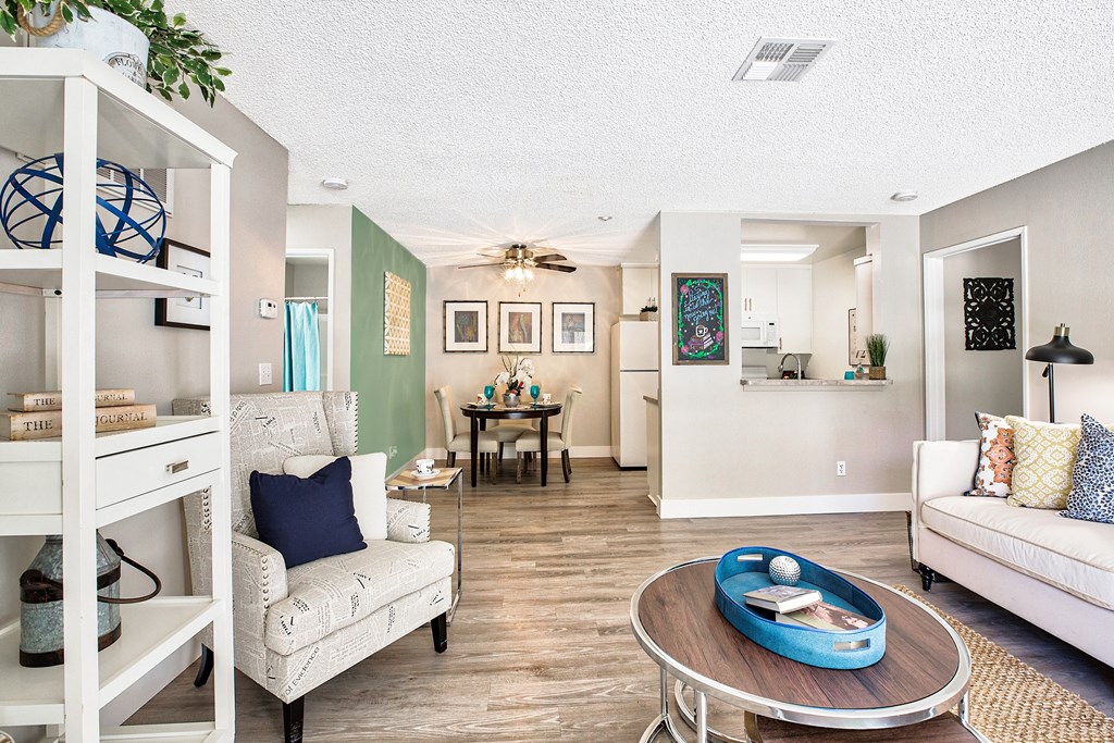 A living room with a white couch, a coffee table, and a dining table at Mountain Vista, Victorville, CA
