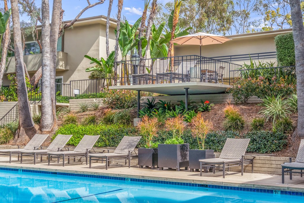 A pool surrounded by chairs and trees at West Park Village, Los Angeles, CA