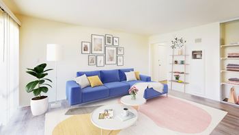 A living room with a blue couch, a coffee table, and a potted plant at West Park Village, Los Angeles, 90025