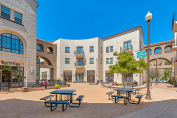 a city square with tables and benches in front of a building at The Villas at Anacapa Canyon, Camarillo, California