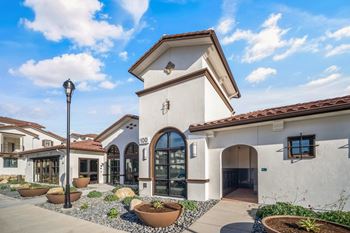 A white building with a brown roof and a black lamp post in front at The Villas at Anacapa Canyon, Camarillo