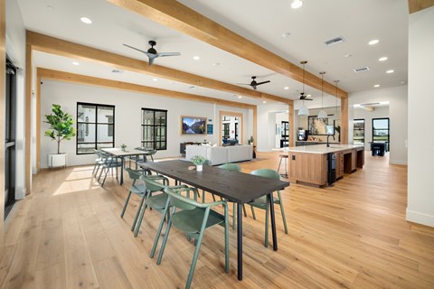A modern dining room with a long table and chairs.