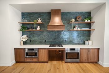 A kitchen with a blue brick wall and wooden cabinets at The Villas at Anacapa Canyon, Camarillo
