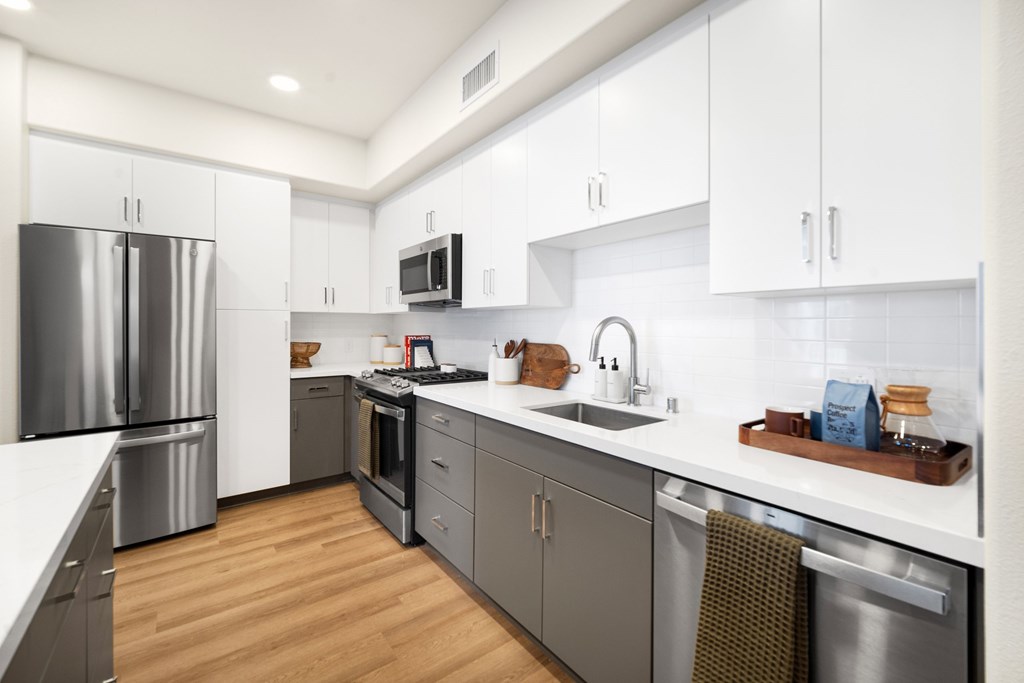 A modern kitchen with stainless steel appliances and wooden floors at The Villas at Anacapa Canyon, Camarillo, 93012