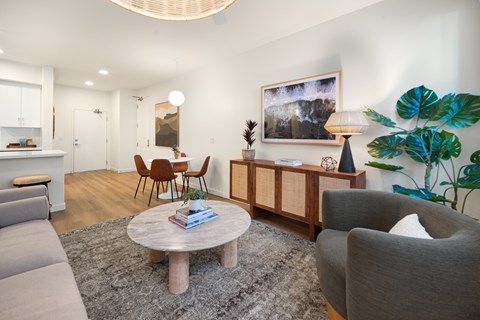 A living room with a grey couch, a wooden coffee table, and a grey armchair.