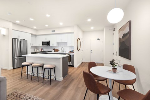A modern kitchen with a bar area and a dining table set up.