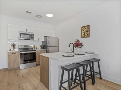 A kitchen with a white counter top and a white oven.