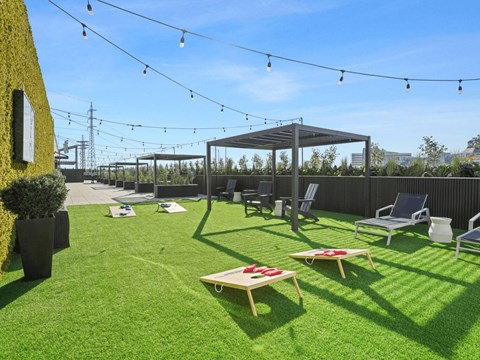 A backyard with a lawn, a gazebo, and a string of lights.