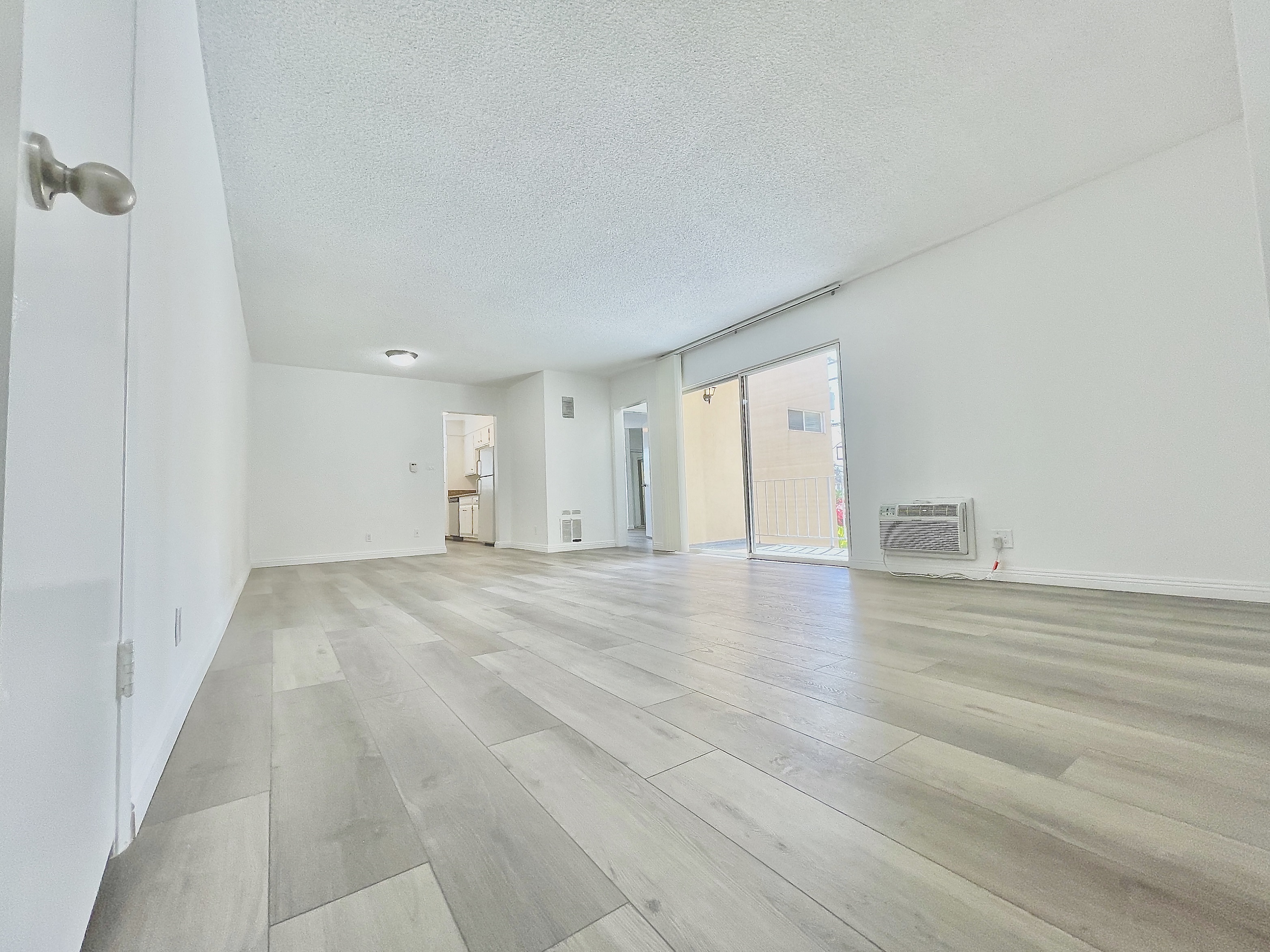 the living room and dining room of an apartment with wood flooring