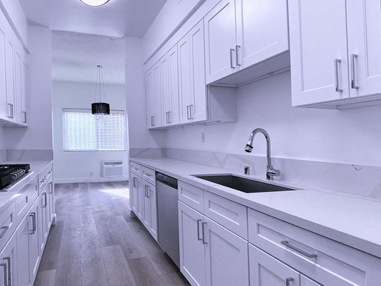 Kitchen With White Cabinets, Sink, and Hard Floor