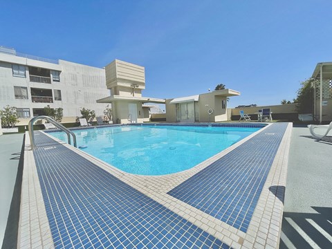 a large swimming pool with a building in the background
