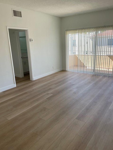 the living room of an empty apartment with wood flooring