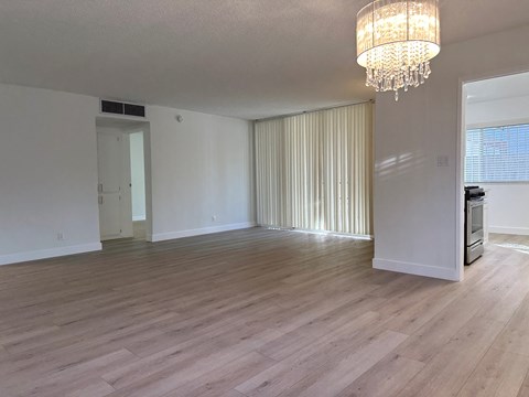 a living room and dining room with wood flooring and a chandelier