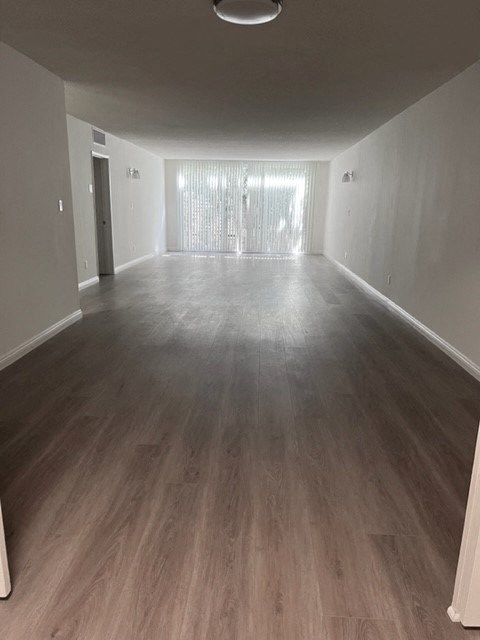 an empty living room with a wood floor