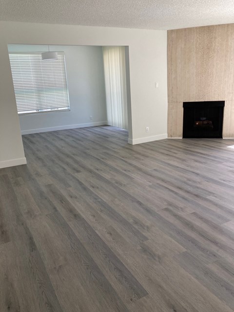 a living room with a fireplace and wooden floors