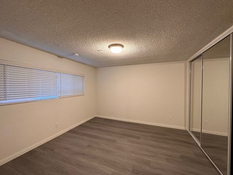a bedroom with a mirrored closet and a large window