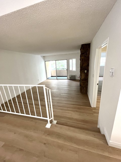the view from the top of the stairs looking into the living room and dining room