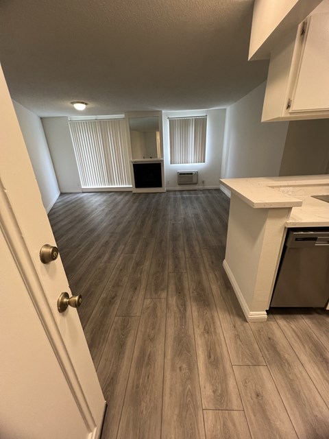 an empty kitchen and living room with hardwood floors