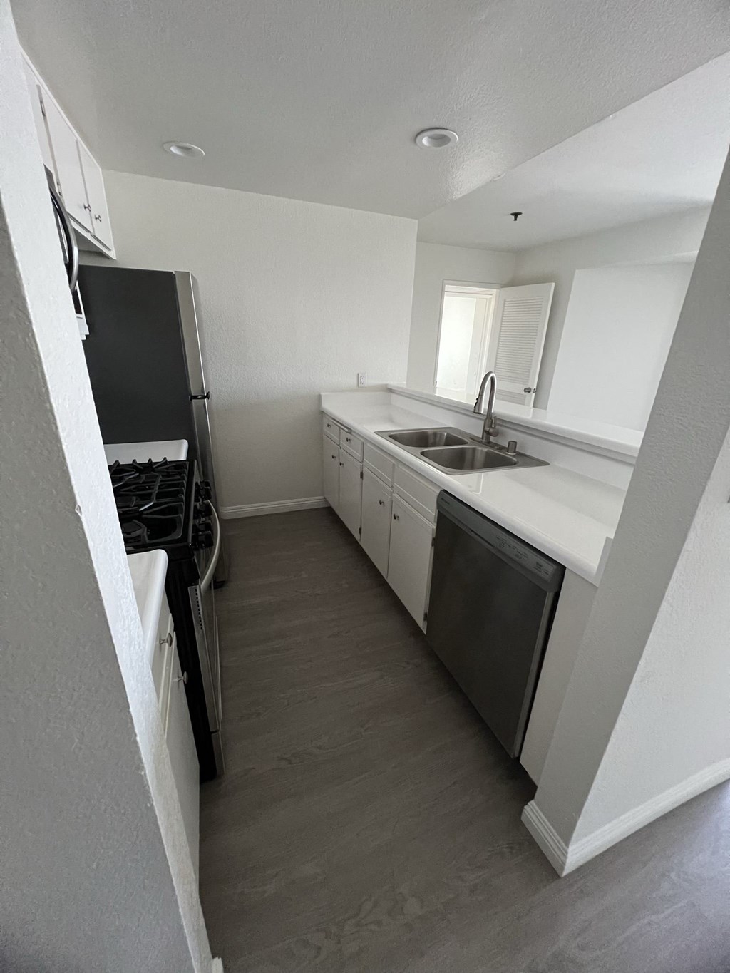 Kitchen with Hardwood Floors, White Cabinets and Stainless Steel Appliances