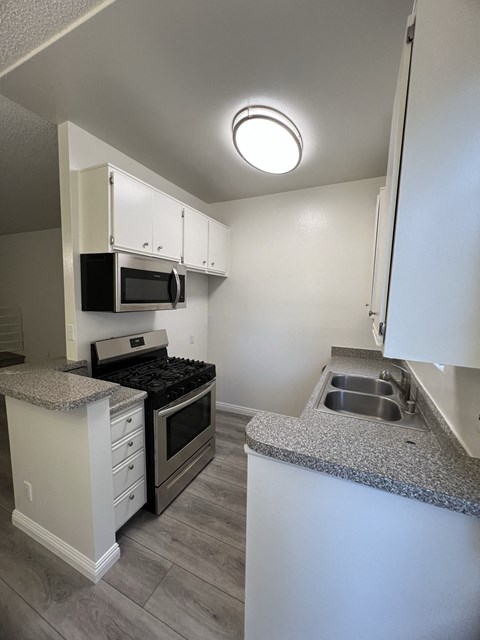 an empty kitchen with granite counter tops and stainless steel appliances