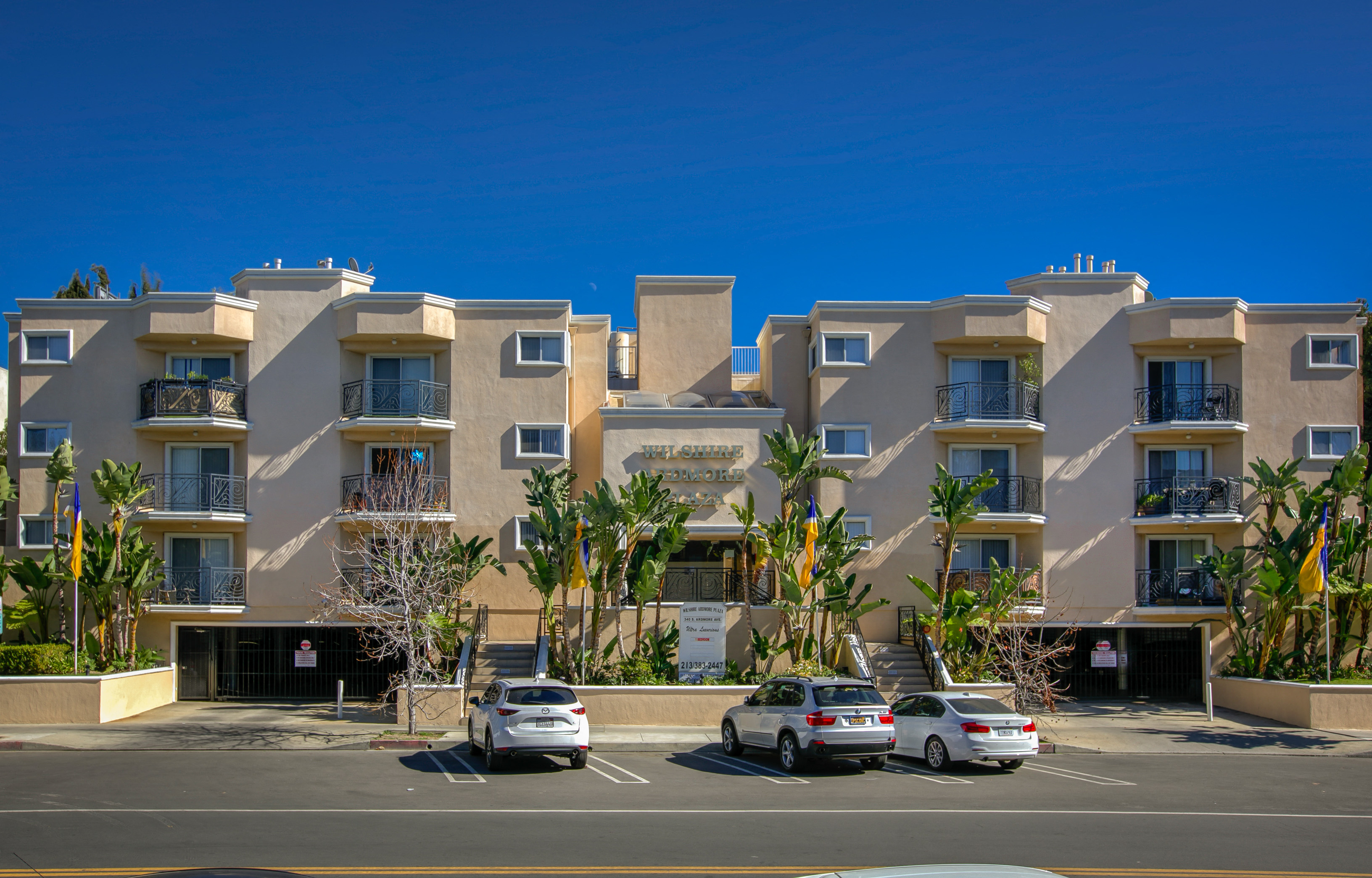 a large apartment building with cars parked in front of it