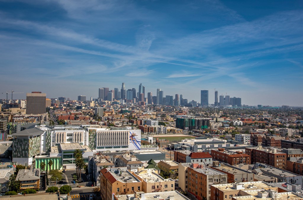 A cityscape with a mix of modern and older buildings under a clear sky.