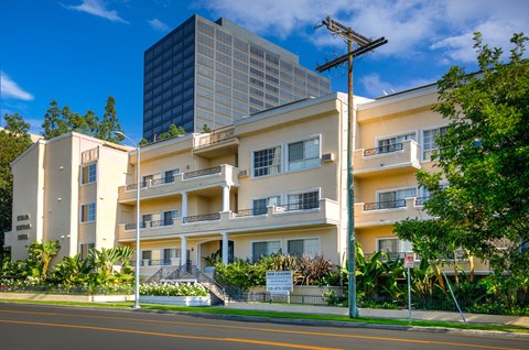 a street view of an apartment complex with a tall building