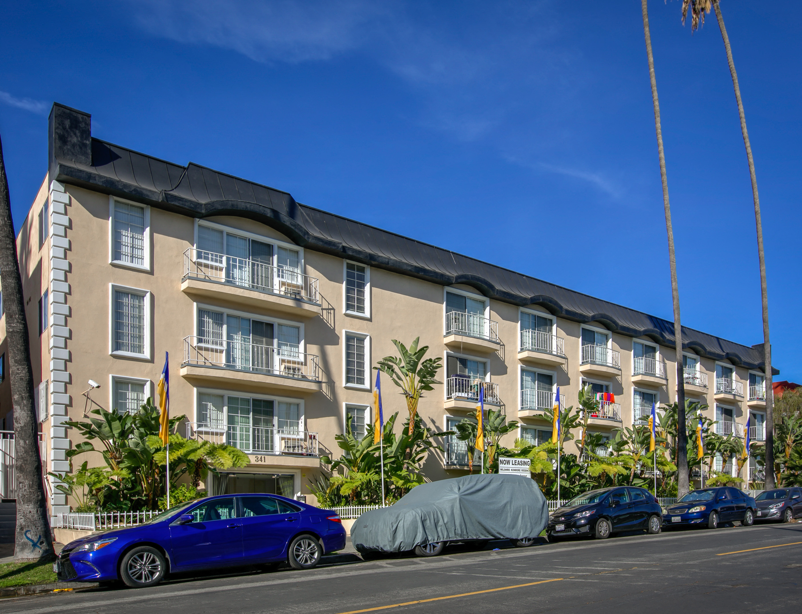 a large apartment building with cars parked in front of it