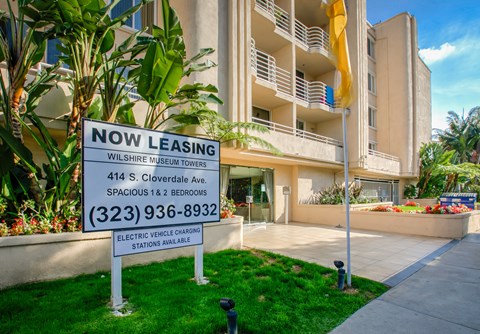 a now leasing sign in front of an apartment building