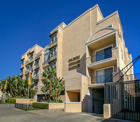 a large apartment building with palm trees in front of it