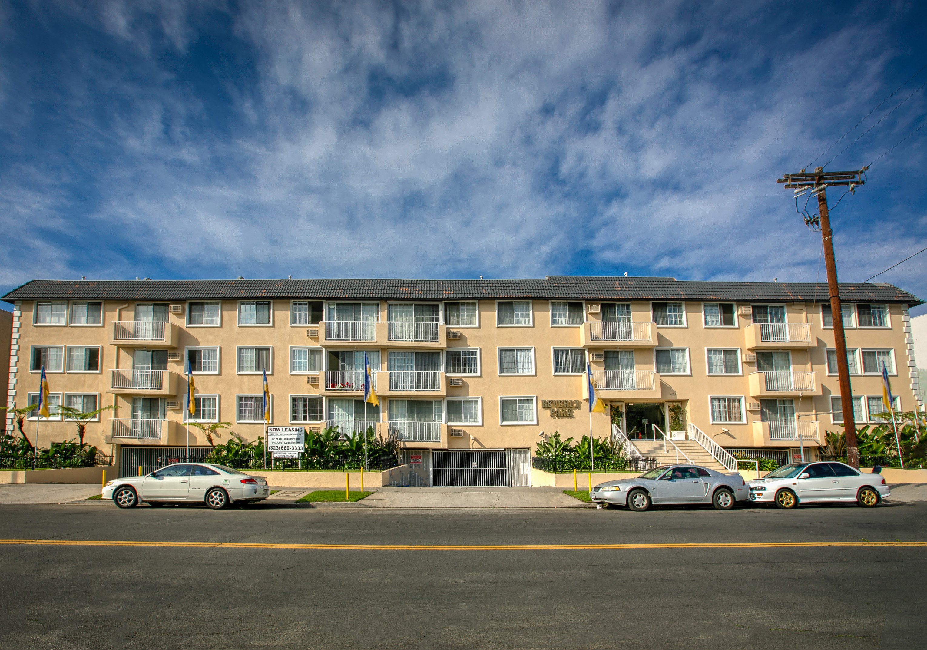 a large apartment building with cars parked in front of it