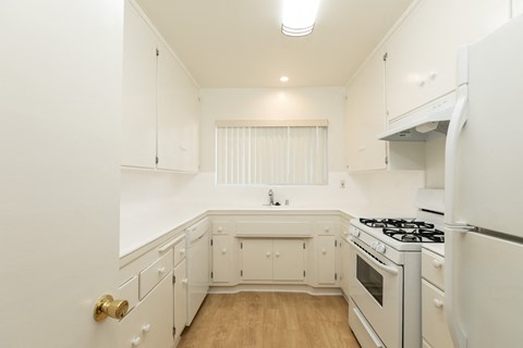 a kitchen with white cabinets and a stove and a refrigerator