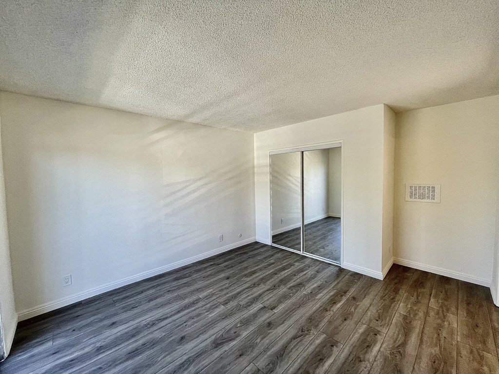 Bedroom with Hardwood Floors and Mirrored Wardrobe Closet