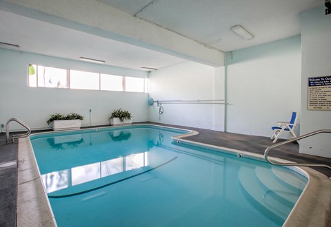 a swimming pool in a hotel room with a blue pool