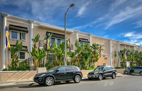 the exterior of a building with cars parked in front of it