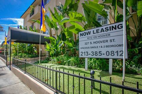 a now leasing sign in front of a building