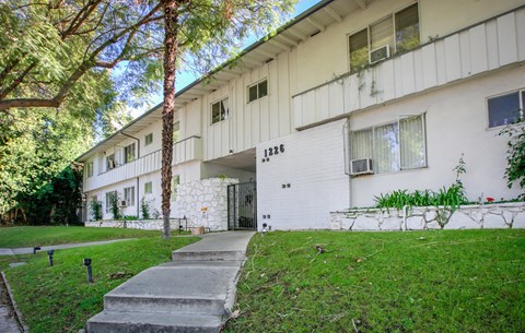 a white building with a sidewalk in front of it