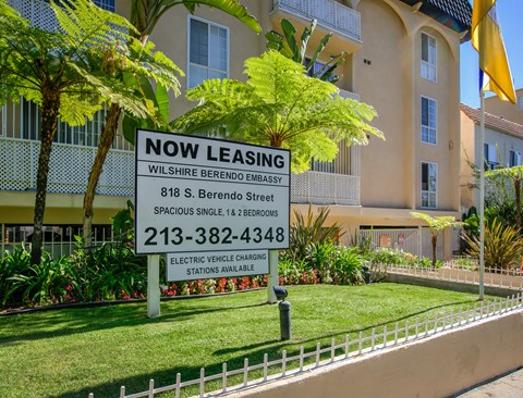 a now leasing sign in front of an apartment building