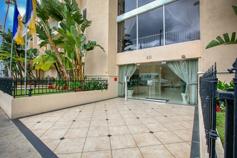 the entrance to a building with a tiled floor and a glass door