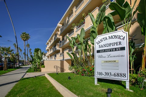 the sign for the apartment is displayed in front of the building