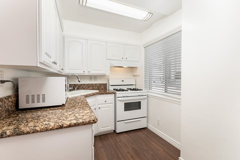 a kitchen with white appliances and granite counter tops