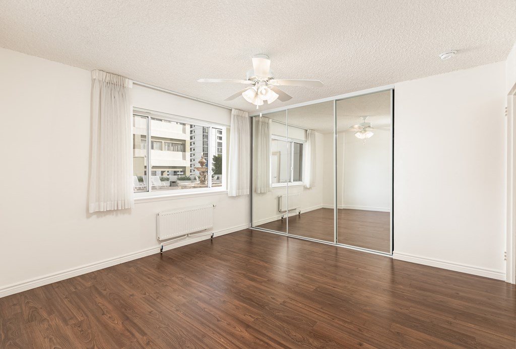 Bedroom with Hardwood Floors and Mirrored Wardrobe Closet